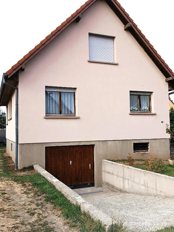 a white house with a brown garage at alsacecoeur in Ungersheim