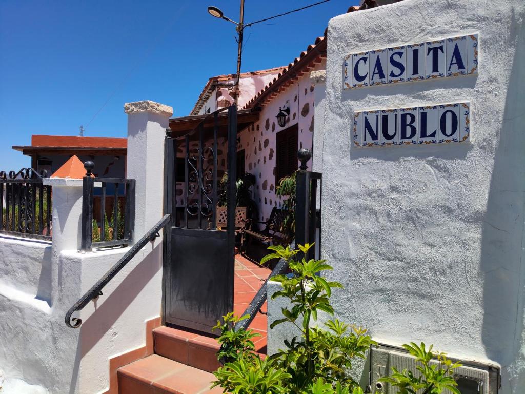 a white building with a sign for a nucinyl at Casita Roque Nublo in Tejeda