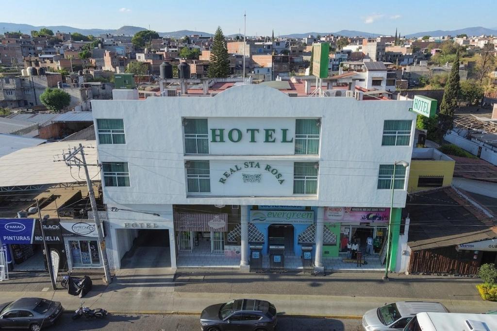 a hotel building with cars parked in front of it at Hotel Real Santa Rosa in Morelia