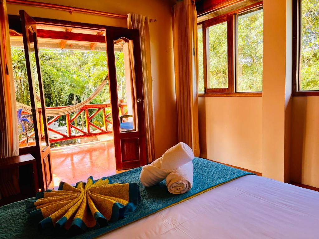 a bedroom with a bed with towels and a window at Hosteria Chuquitos - Chalupas in Tena