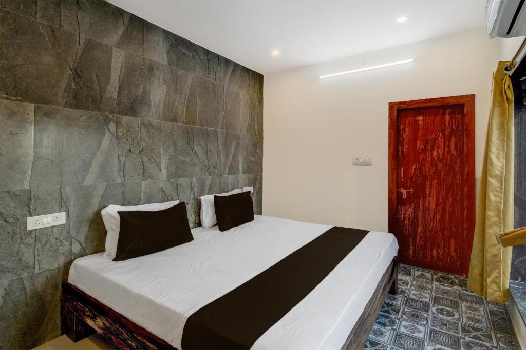 a bedroom with a bed and a red door at Hotel O Dream Vegas in Hyderabad