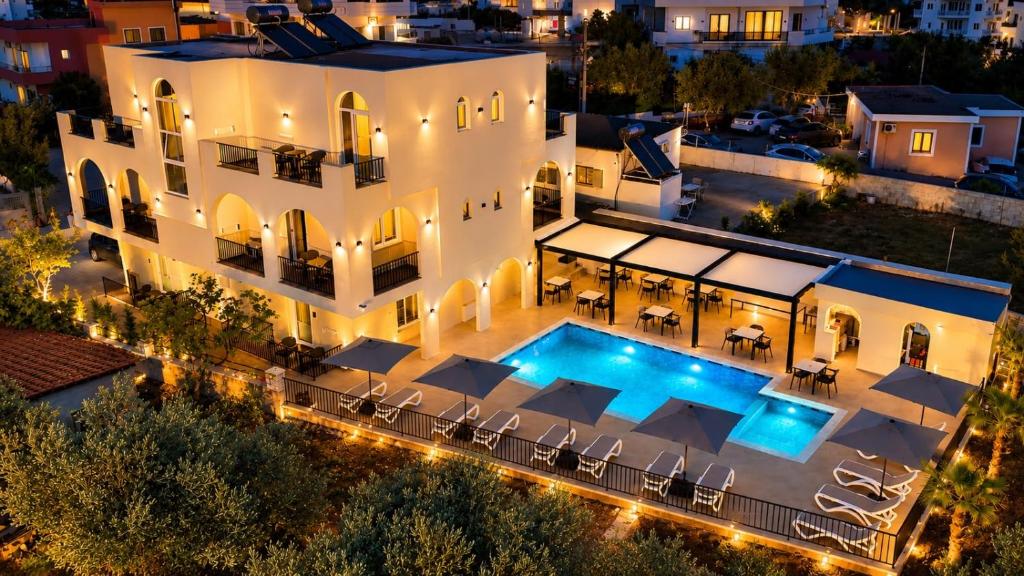 an aerial view of a villa with a swimming pool at night at Abelia Hotel in Ksamil
