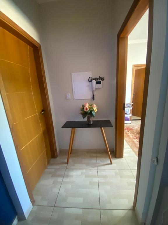 a small table with flowers on it in a hallway at Casa da tami in Bonito