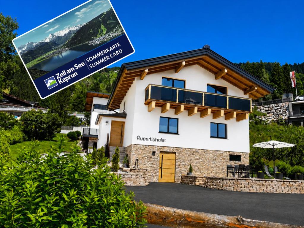 a house in the mountains with a sign in front of it at Rupertichalet in Zell am See
