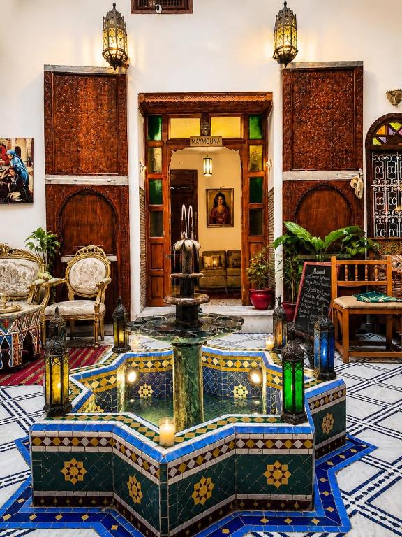 a living room with a fountain in the middle of a room at Riad Hamad Tijani in Fez