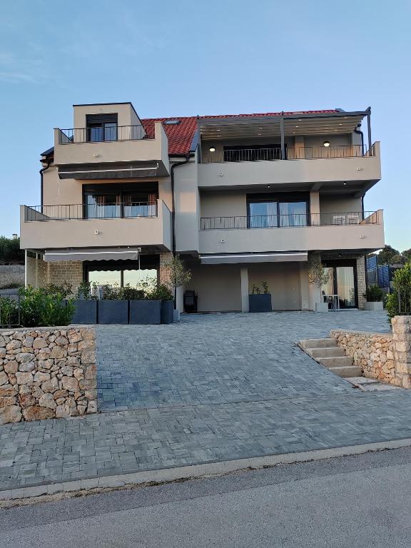 a large apartment building with a stone driveway at Apartments DiVi Sunset View in Mandre