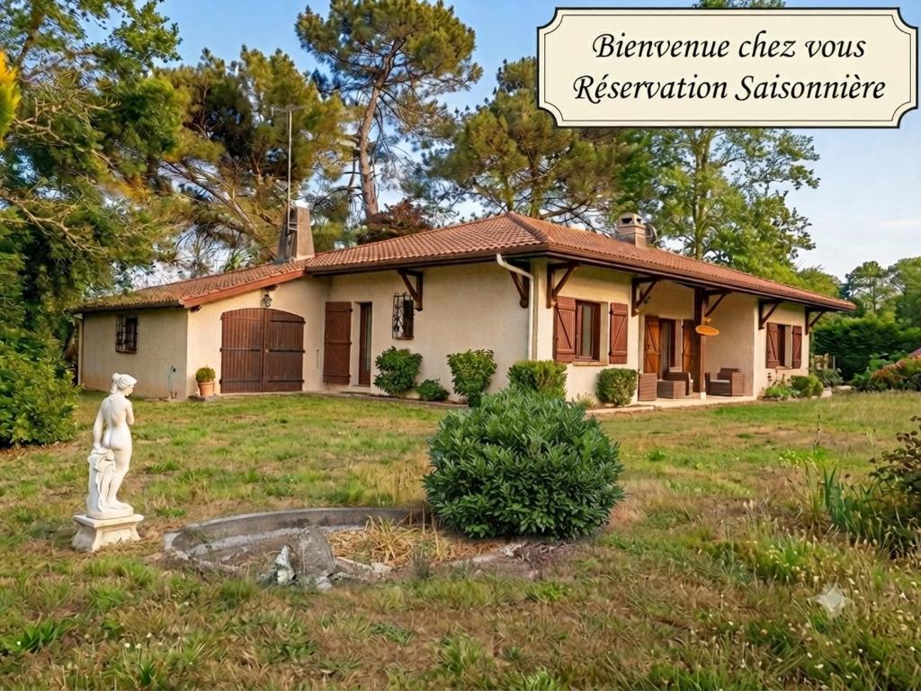 a house with a statue in front of it at Le Petiou Landais in Soustons