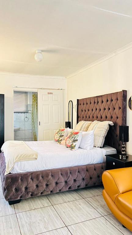 a bedroom with a large bed with a brown headboard at KaChichima in Springs