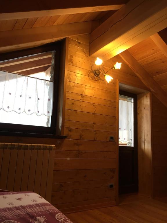 um quarto com paredes de madeira e uma janela em Maison Giulietta em Fontainemore