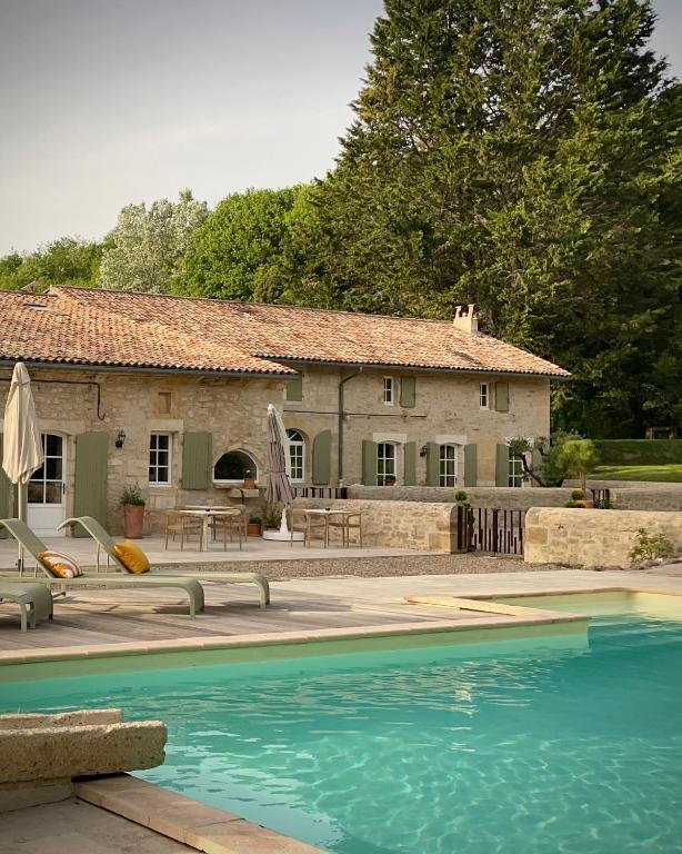 a house with a swimming pool in front of a house at Maison Girardine in Rauzan