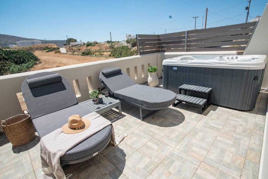 a patio with a hot tub and a table and chairs at Aurora Horizon Naxos in Glinádhon