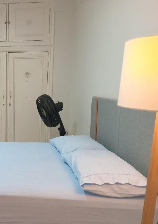 a bedroom with a bed with a lamp next to it at Capsula Residence Hotel in Marília