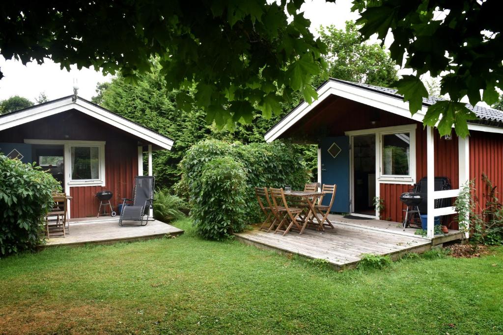 a red house with a deck and a table at B&B Olsegården in Tvååker