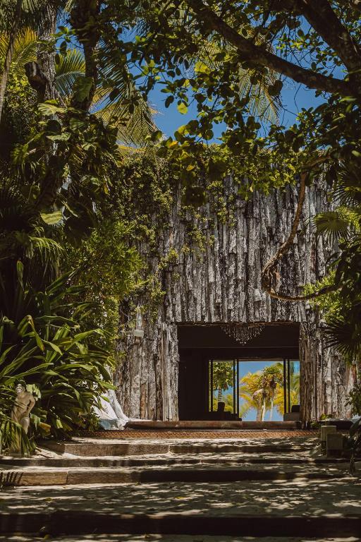 ein großer Eingang zu einem Gebäude, der aus einem Baumstamm gefertigt ist in der Unterkunft Casa Malca in Tulum