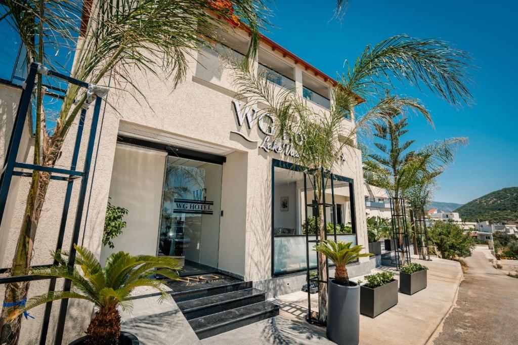 a building with palm trees in front of it at WG Hotel Lake View in Ksamil