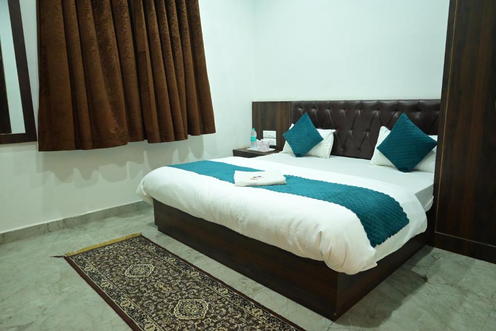 a bedroom with a large bed with blue pillows at Hotel sphatic in Chitrakoot