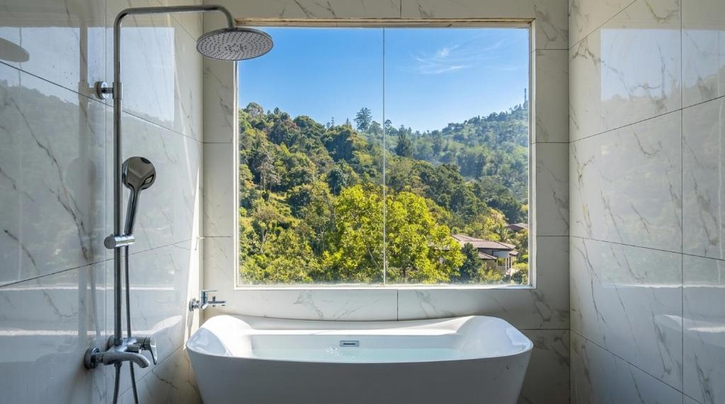 a bathroom with a bath tub and a window at Ceylon tea resort Ella in Ella