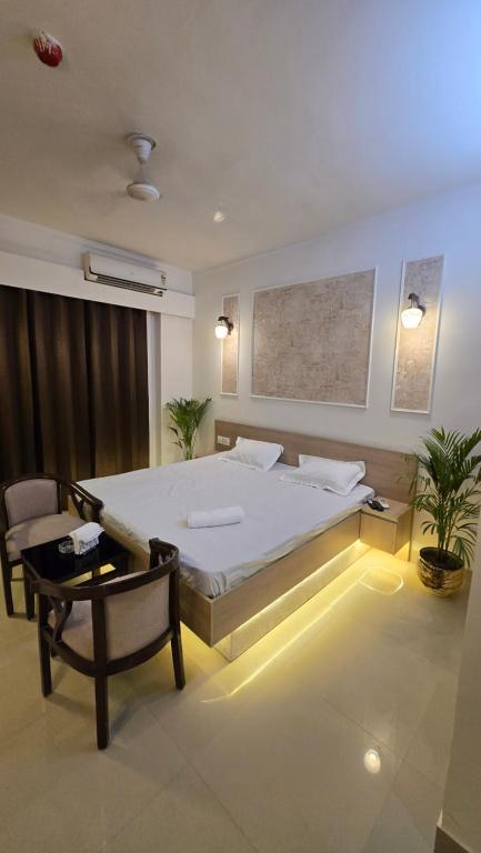 a bedroom with a large bed and a chair at Modern Studio With Balcony & Raod Facing View in Noida