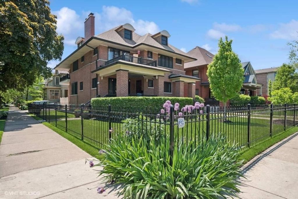 a fence in front of a house with flowers at Your Chicago Retreat in Chicago