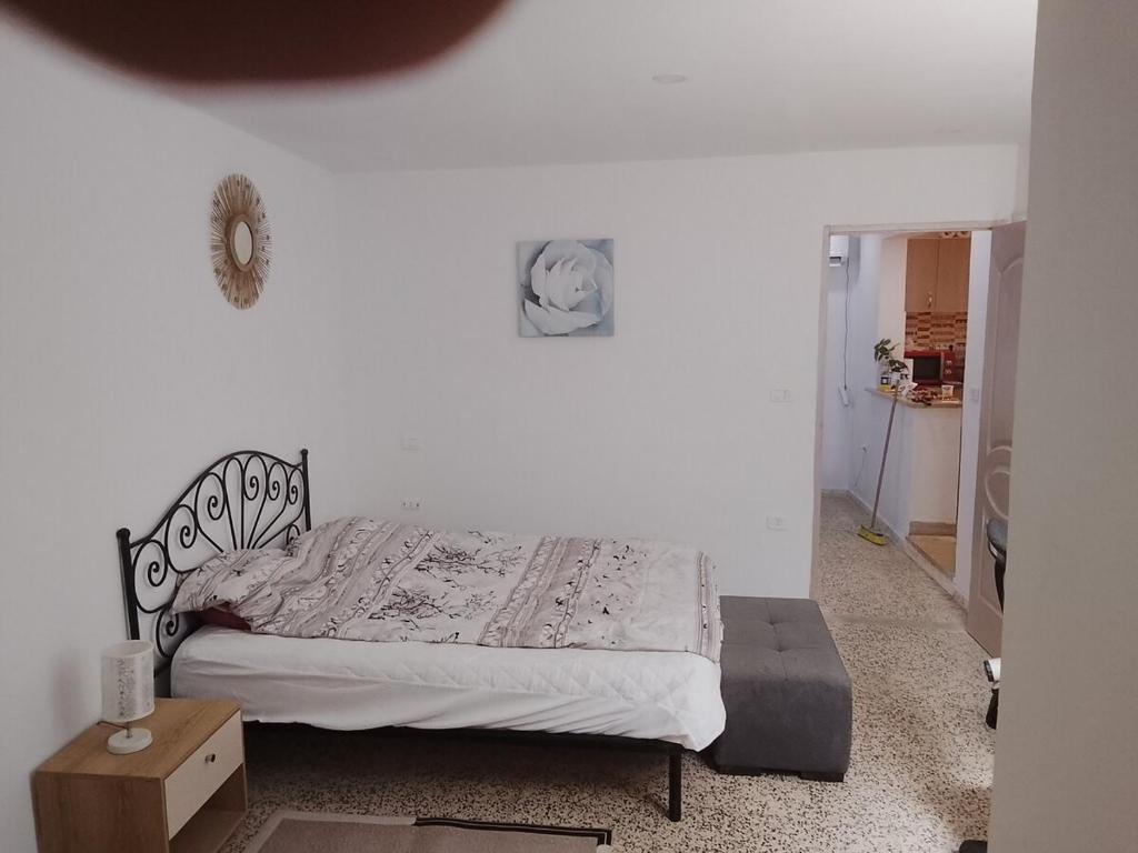 a bed in a bedroom with a white wall at Studio in La Goulette