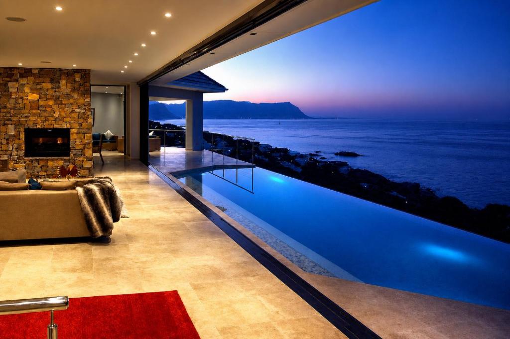 a house with a swimming pool with a view of the ocean at Aqua Terra Boutique Guesthouse - Simon's Town, Cape Town in Simonʼs Town