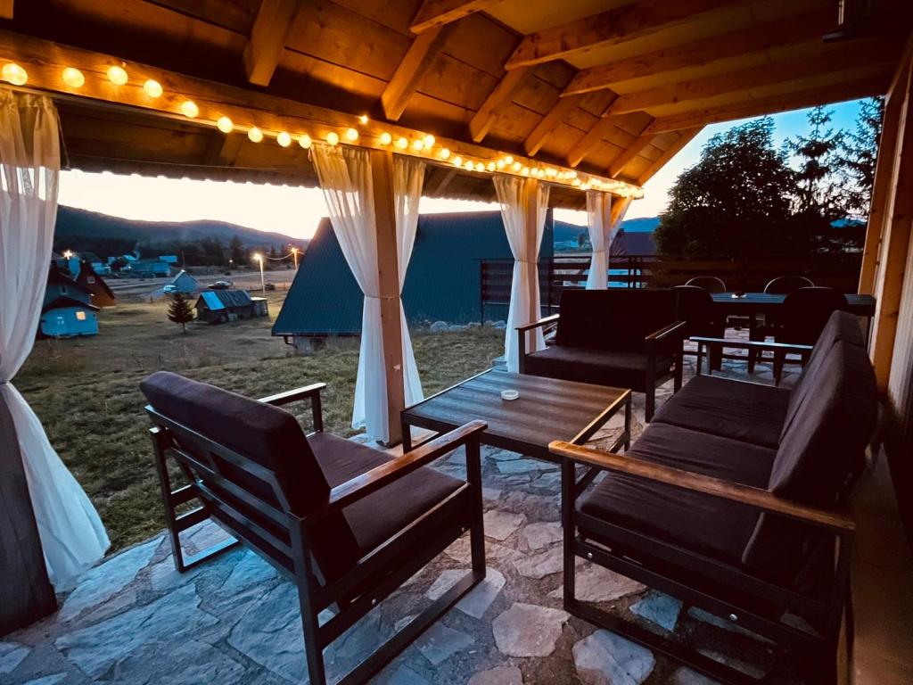 a patio with chairs and a table and lights at Mountain Peace Cottage in Žabljak