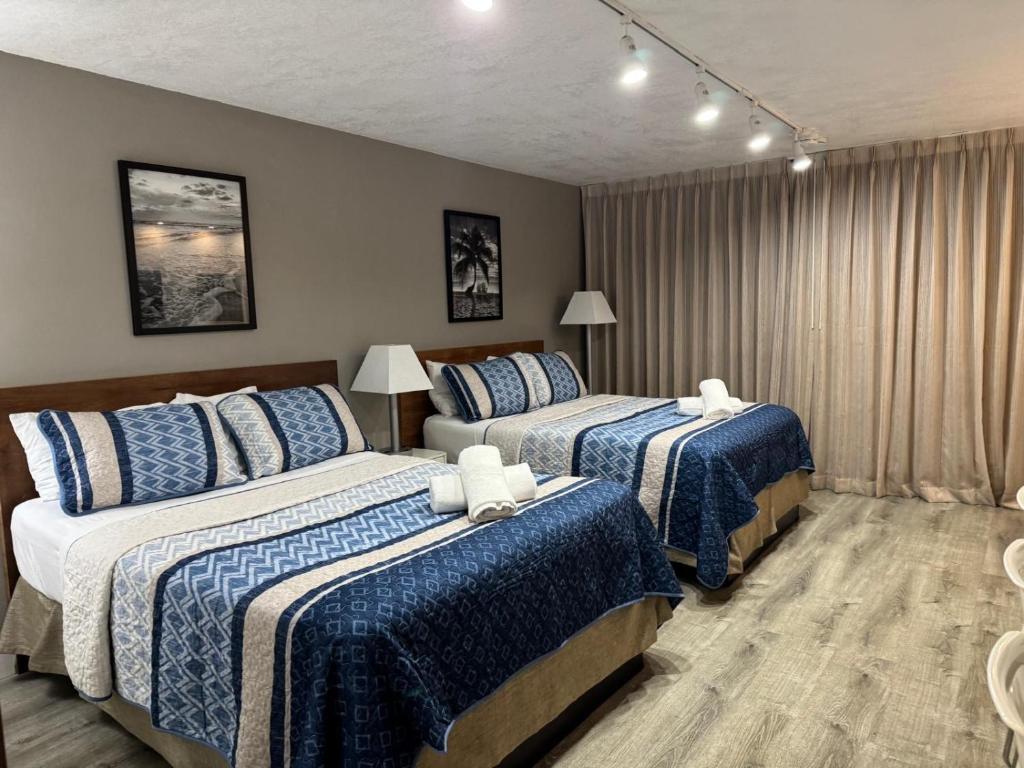 a bedroom with two beds with blue and white sheets at Renovated Beachfront Condo with Balcony in Sunny Isles Beach