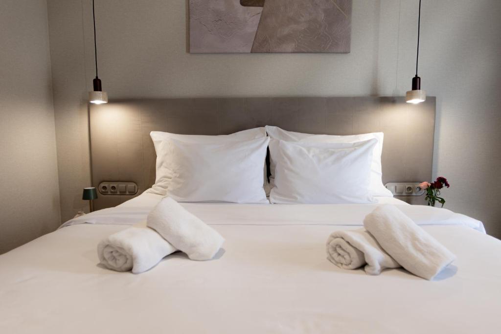a bed with white pillows and towels on it at Moment in Strzelce Opolskie