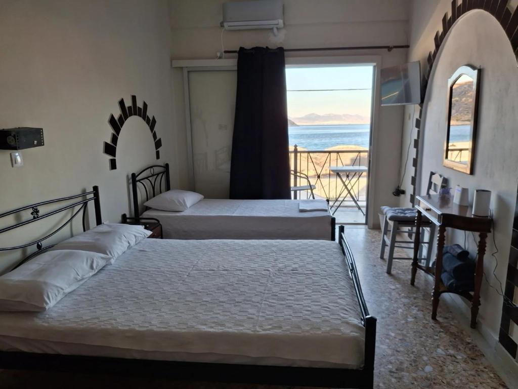 two beds in a room with a view of the ocean at Salamina Sea View in Kakí Vígla