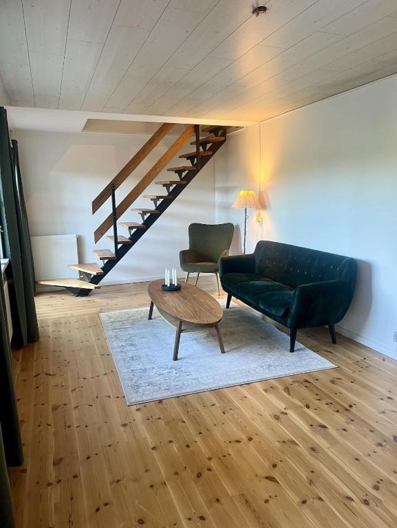 a living room with a black couch and a table at The Blue Country House in Nørre Broby