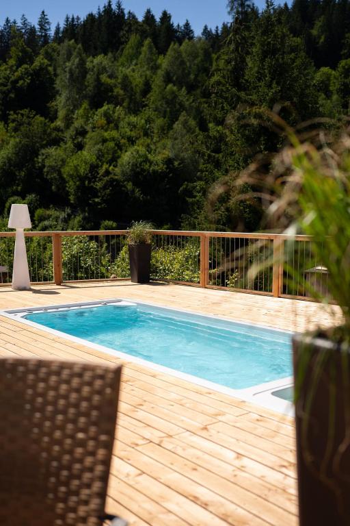 a swimming pool with a wooden deck at ALMMONTE LIGNUM - Premium Lodge in Wagrain