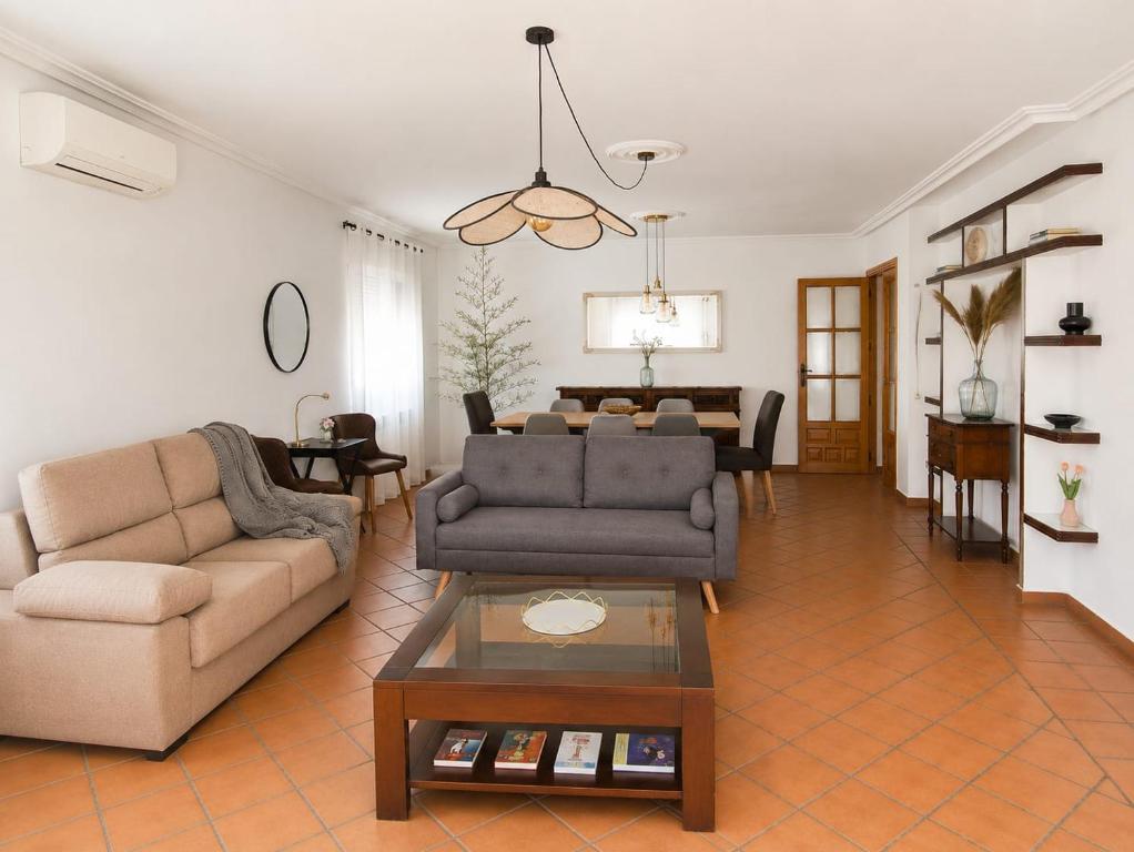 a living room with two couches and a table at El encinar de las nieves - Piscina privada, cerca de Toledo y Puy du Fou in Toledo