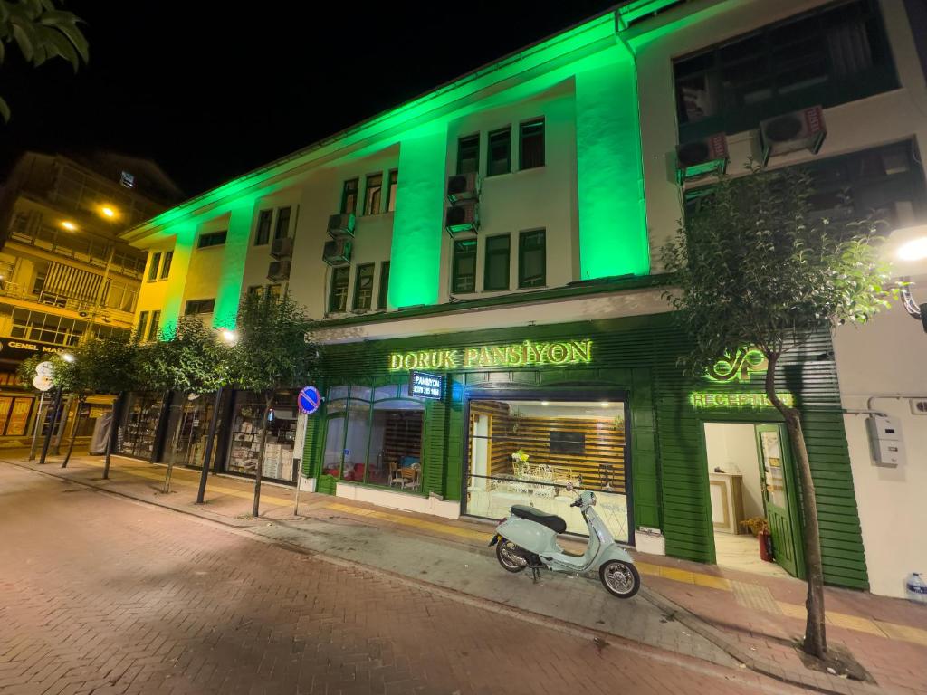 a scooter parked in front of a building with green lights at Doruk Pansiyon in Amasra