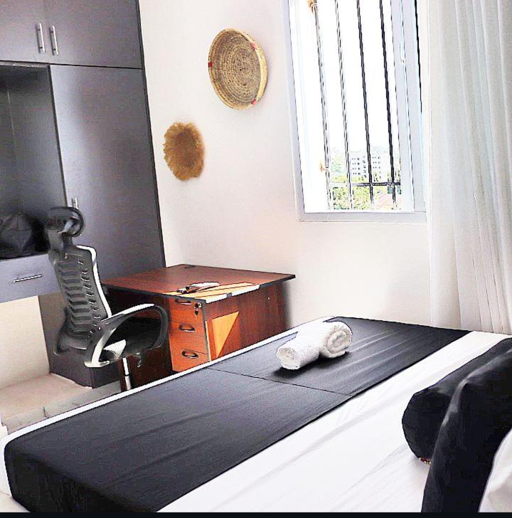a bedroom with a bed and a desk and a mirror at Soft stay homes in Mombasa