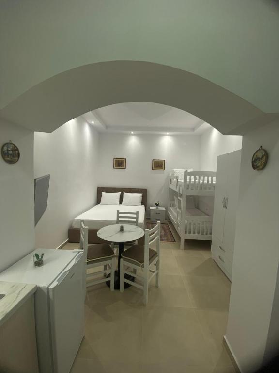 a room with a bed and a table and a bedroom at Casa de Flori in Përmet