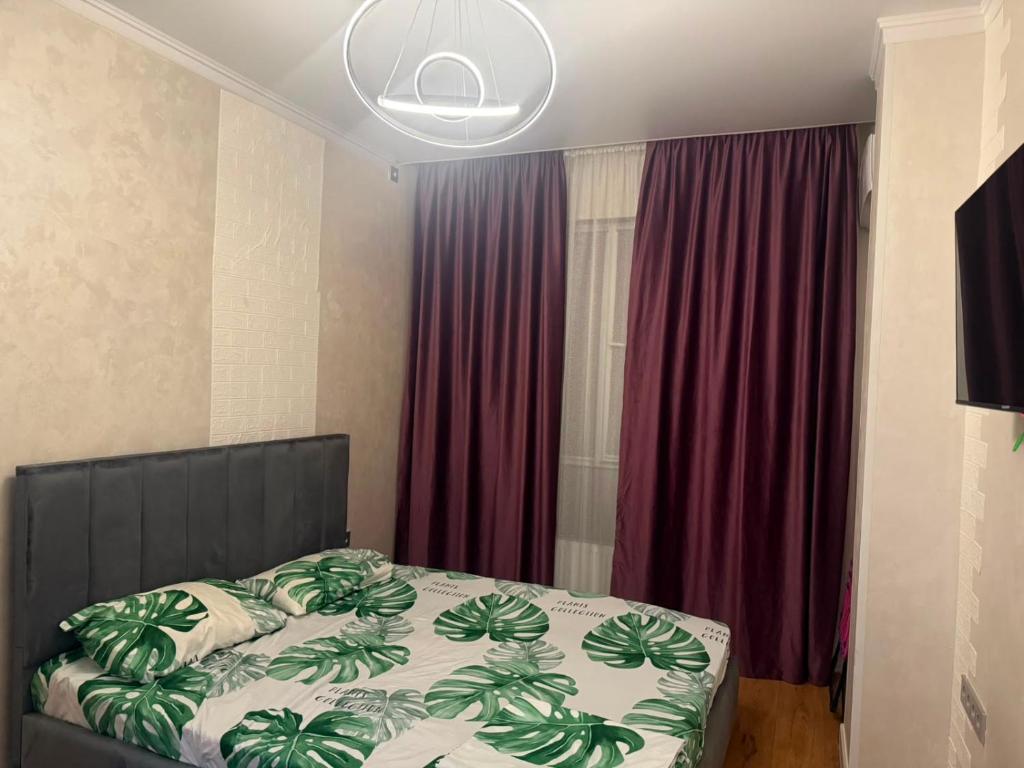 a bedroom with a bed with a black head board at Жилой Комплекс Kemel-UI in Qaskeleng