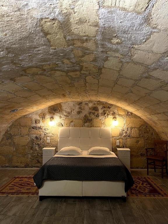 a bedroom with a white bed in a stone wall at Au 47 in Bordeaux