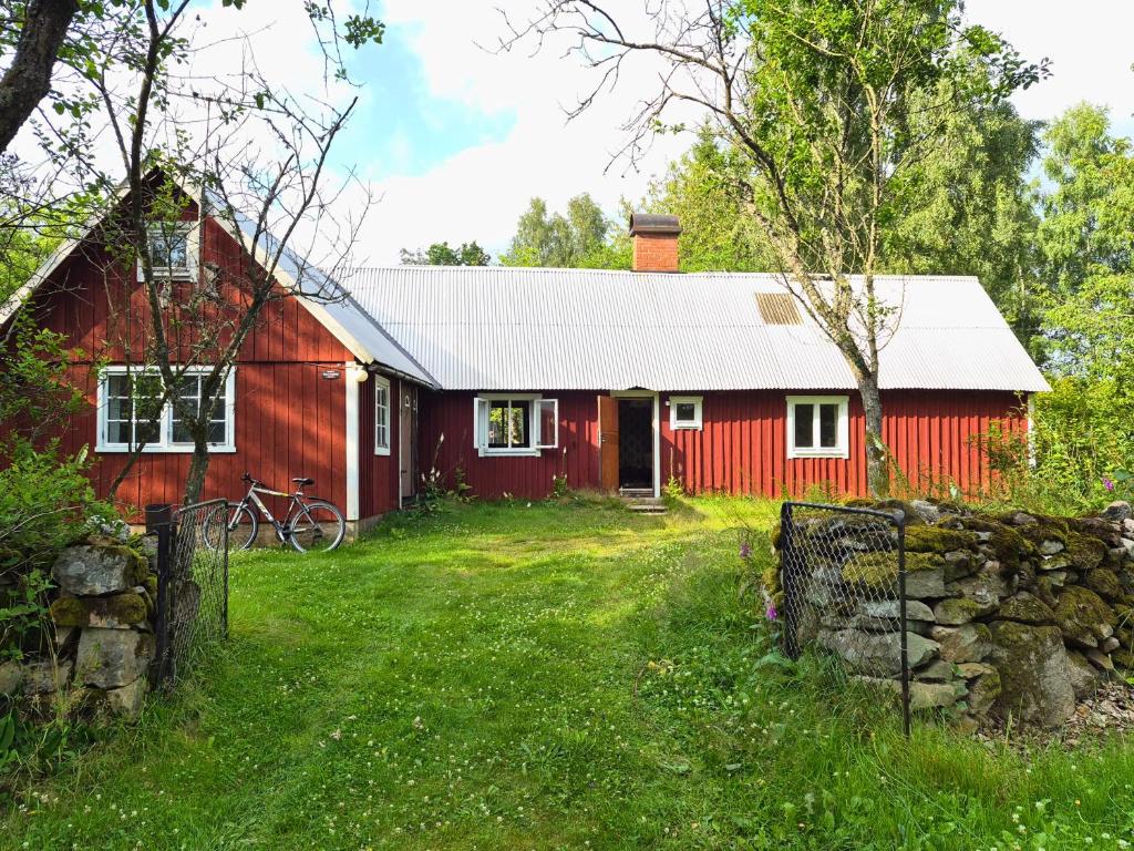 a red barn with a fence in front of it at Scandinavian forest retreat in Ljungbyhed