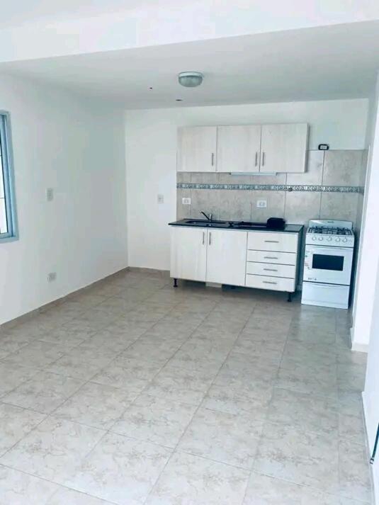 an empty kitchen with white cabinets and a stove at Los Bajitos in Maipú