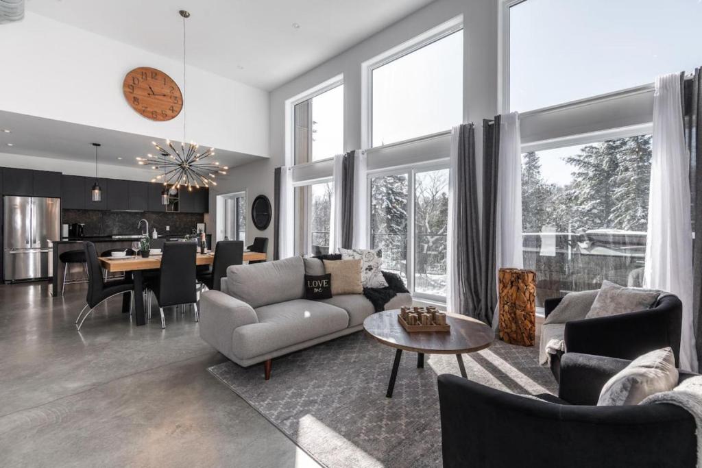 a living room with a couch and a table at Luxurious Villa Tremblant 4 Bdrs W Hot Tub B85 in Mont-Tremblant