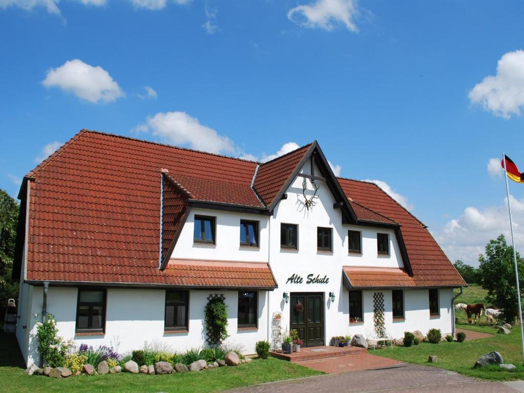 a white house with a red roof at Wohnung in Dargun mit Garten in Barlin