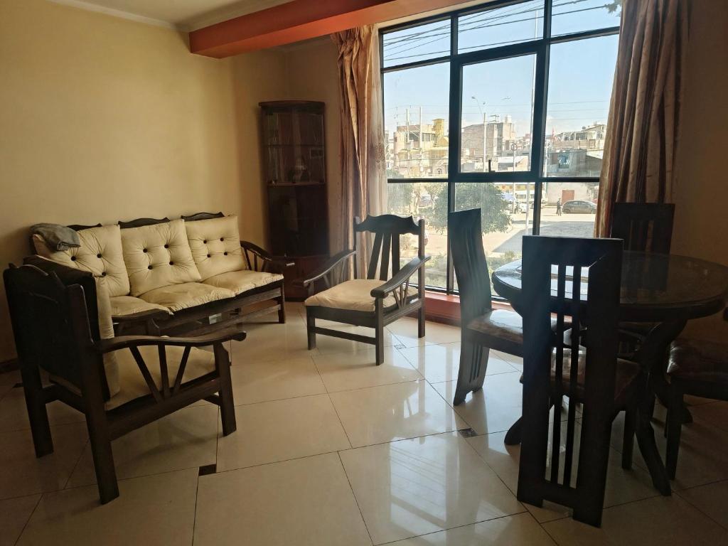 a living room with a couch and chairs and a table at APART TOSCANO Suites in Huancayo