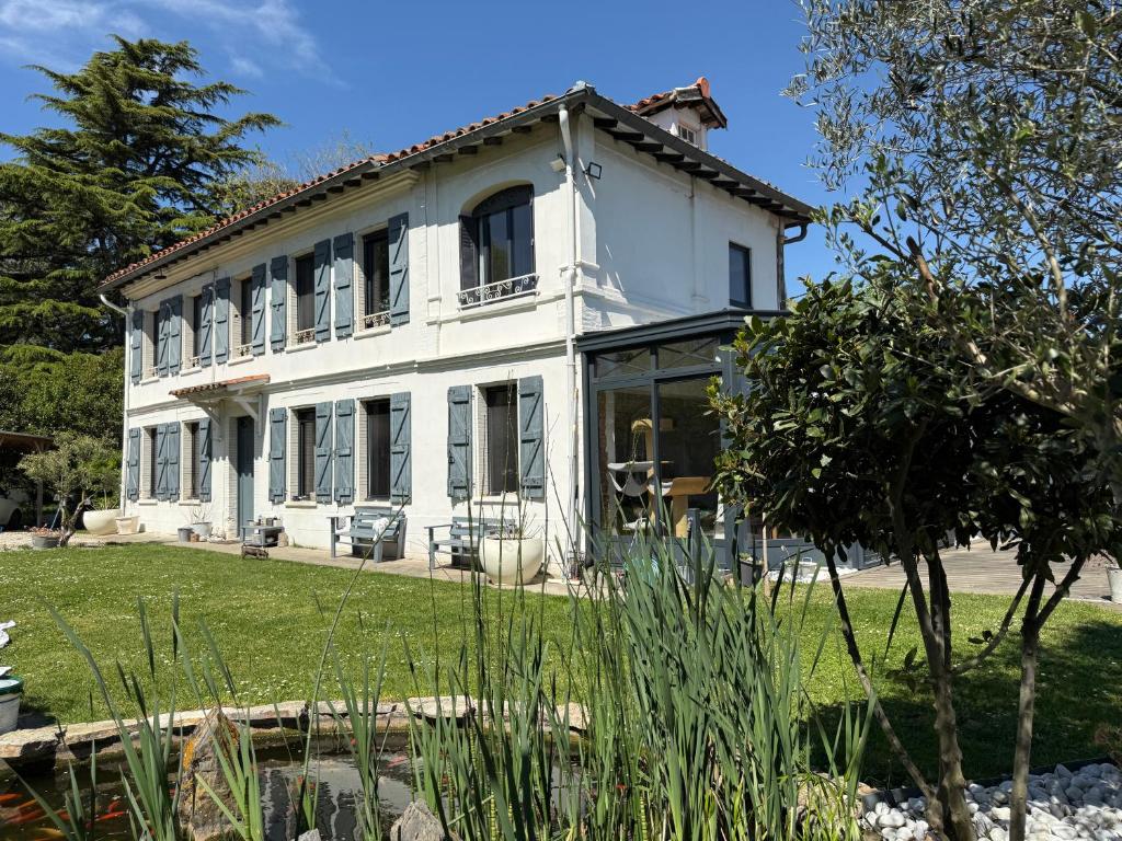 a white house with windows and a yard at Studio Cosy in Castanet-Tolosan