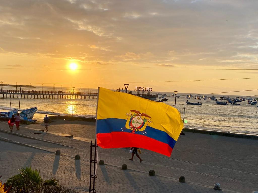 a flag in front of a beach with a pier at Casa de Heidi in Puerto López