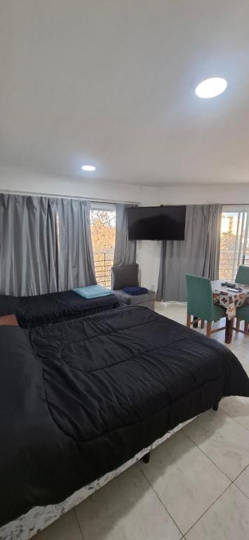 a bedroom with a large black bed in a room at Apartamento Monte Grande Ameghino in Monte Grande