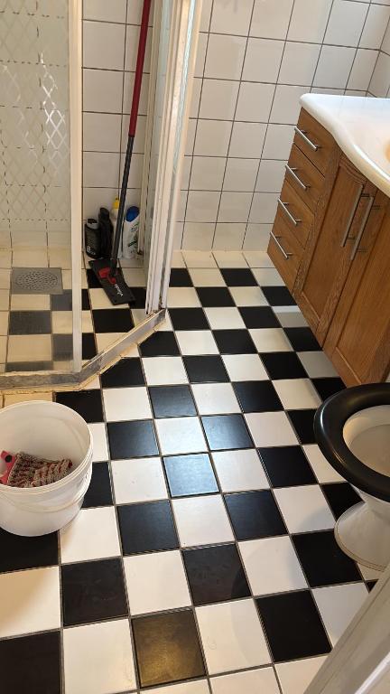 a bathroom with a black and white checkered floor at Vila in Hultsfred