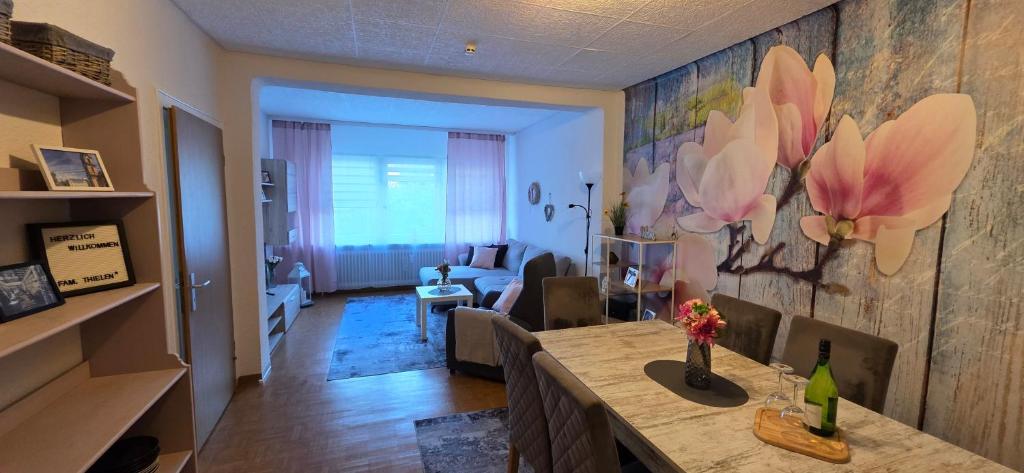 a living room with a table with flowers on the wall at Ferienwohnung FeLuMi in Wadgassen