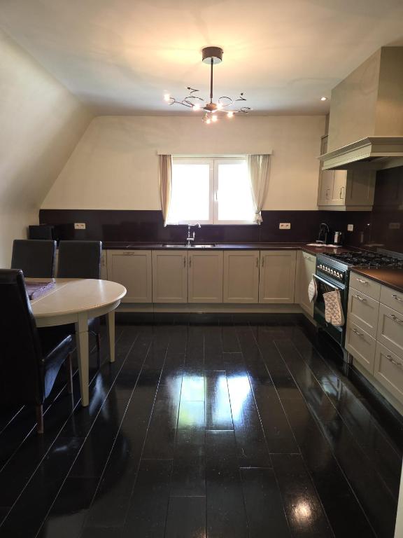 a large kitchen with a table and a window at All Together in Rupelmonde