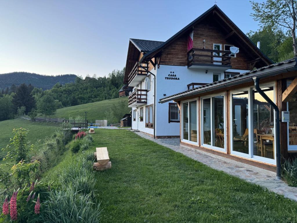 a house with a grass yard next to a building at Casa Teodora in Albac
