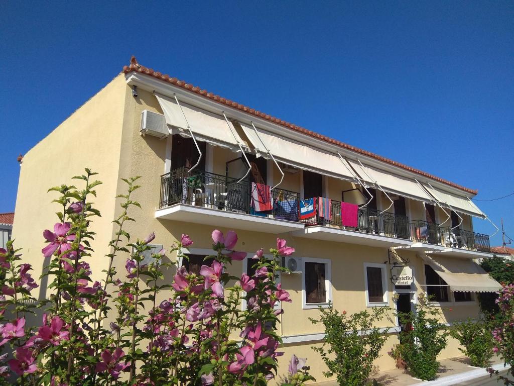 a building with pink flowers in front of it at Castello Methoni in Methoni